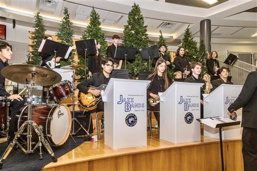 A jazz band performs in front of evergreen trees